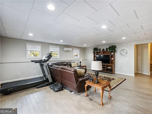 living room with baseboards, an AC wall unit, recessed lighting, and light wood-style floors