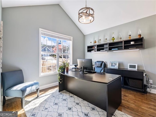 home office featuring lofted ceiling, baseboards, an inviting chandelier, and wood finished floors