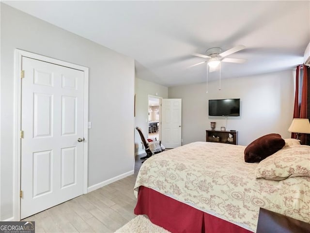 bedroom featuring baseboards, ceiling fan, and light wood-style floors