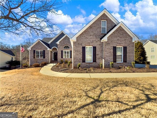 traditional-style home with a front yard and brick siding