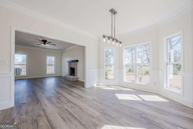 3800 George Williams Rd, Monroe, GA 30656 - unfurnished living room featuring a wainscoted wall, crown molding, wood finished floors, a fireplace, and a decorative wall
