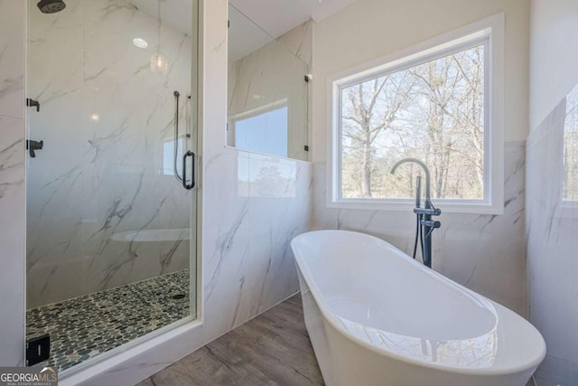 3800 George Williams Rd, Monroe, GA 30656 - full bathroom with wood finished floors, a soaking tub, a marble finish shower, and tile walls