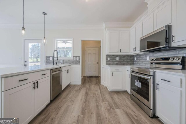 3800 George Williams Rd, Monroe, GA 30656 - kitchen featuring a peninsula, tasteful backsplash, stainless steel appliances, and crown molding