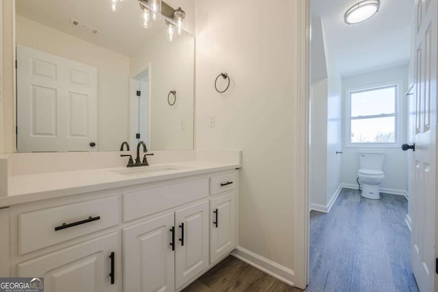 3800 George Williams Rd, Monroe, GA 30656 - bathroom with toilet, wood finished floors, vanity, visible vents, and baseboards