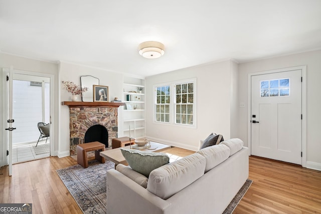 living area with light wood-type flooring, a fireplace, and baseboards