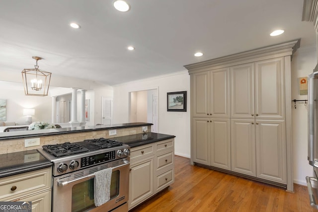 kitchen with dark countertops, cream cabinetry, and high end range