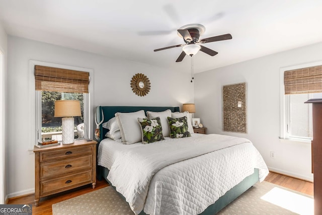 bedroom with ceiling fan, baseboards, and wood finished floors