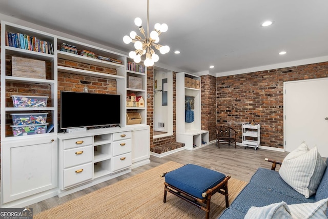 living area featuring light wood finished floors, brick wall, a chandelier, and recessed lighting