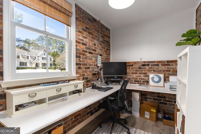 office space featuring brick wall and wood finished floors