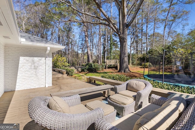 view of patio / terrace featuring a deck, a trampoline, and an outdoor living space