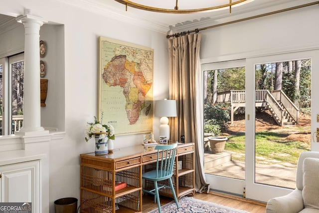 interior space with ornamental molding, decorative columns, and wood finished floors