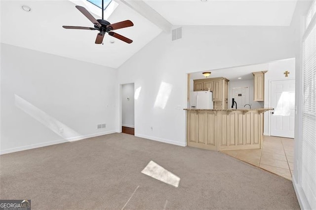 unfurnished living room with beam ceiling, light colored carpet, visible vents, a ceiling fan, and high vaulted ceiling