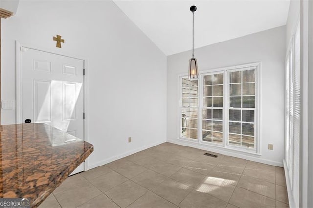 unfurnished dining area with light tile patterned floors, baseboards, visible vents, and high vaulted ceiling