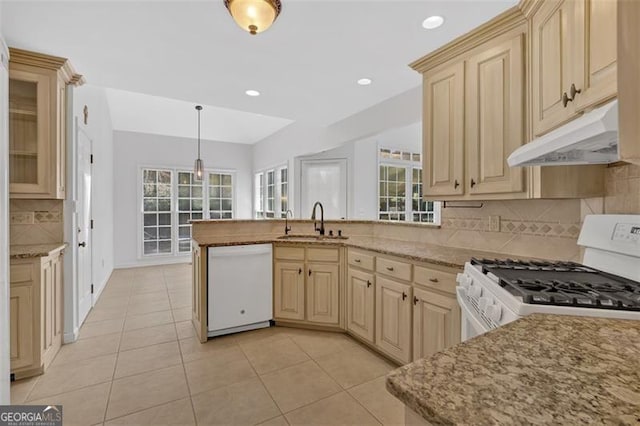 kitchen with a wealth of natural light, a sink, a peninsula, white appliances, and under cabinet range hood