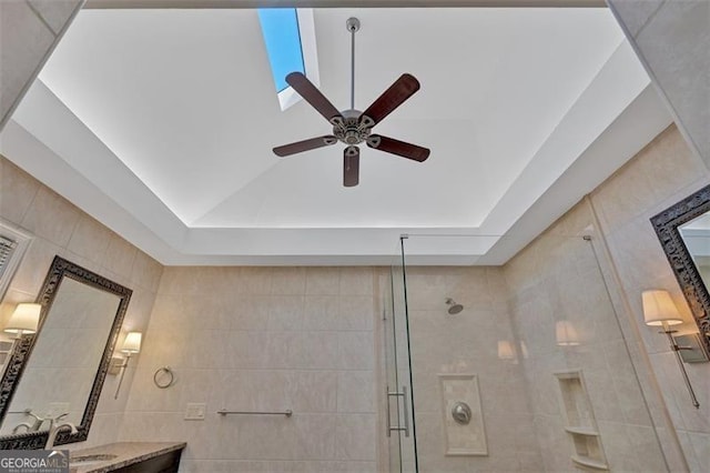 details with a ceiling fan, a tile shower, and vanity