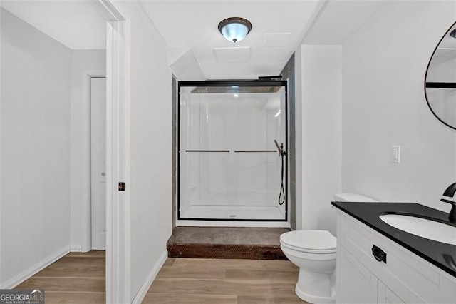 full bathroom with baseboards, toilet, wood finished floors, vanity, and a shower stall