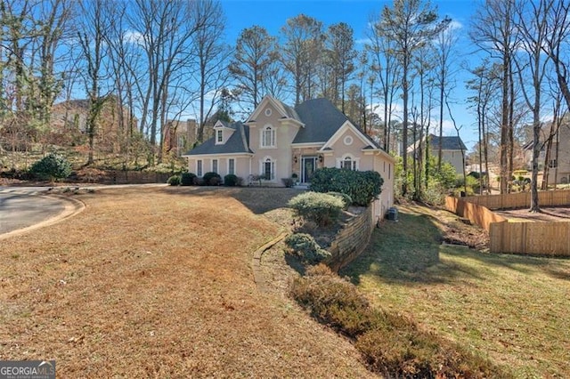 view of front of house featuring fence and a front lawn