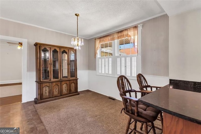 dining area with visible vents, ornamental molding, a textured ceiling, and ceiling fan with notable chandelier