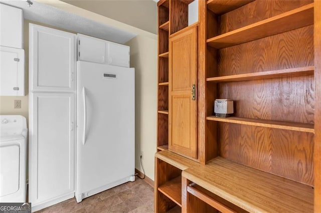 interior space featuring washer / dryer, open shelves, light countertops, and freestanding refrigerator