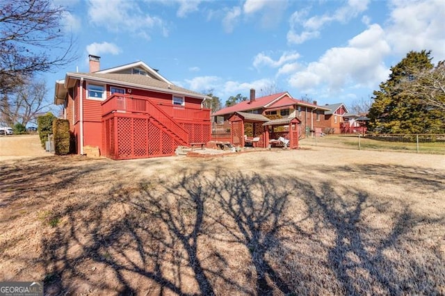 exterior space with a chimney, stairway, fence, and a front yard