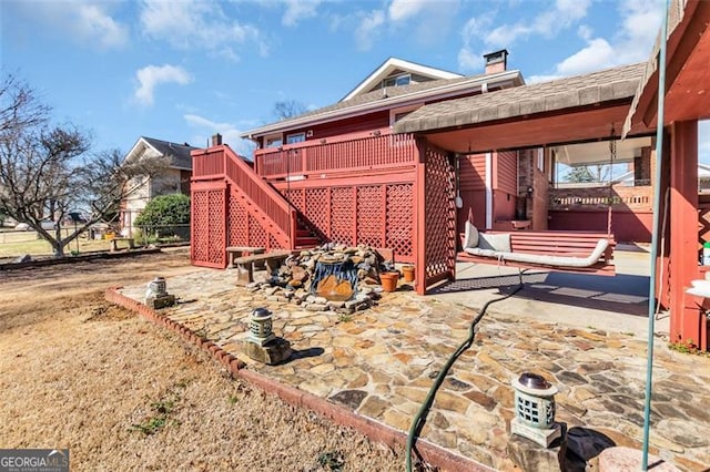 view of side of property featuring a patio area, stairway, and a wooden deck