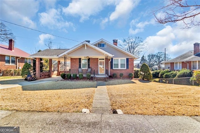 view of front facade with covered porch, a carport, brick siding, and a front yard