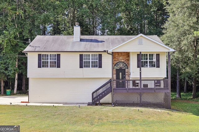 raised ranch with a front lawn, a chimney, and brick siding