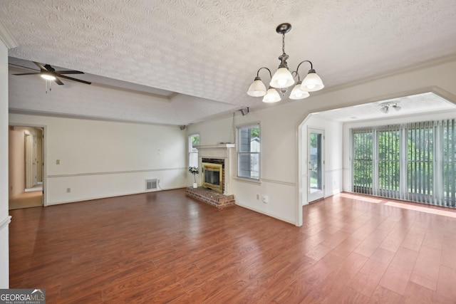 2768 Southpark Blvd SW, Conyers, GA 30094 - unfurnished living room featuring a textured ceiling, healthy amount of natural light, a chandelier, wood finished floors, and crown molding
