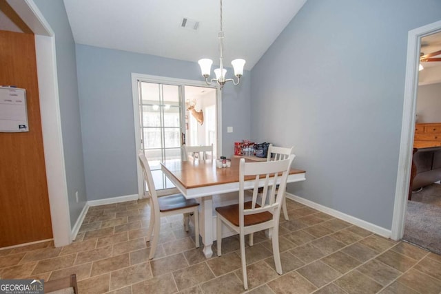 dining room featuring lofted ceiling, baseboards, visible vents, and a notable chandelier