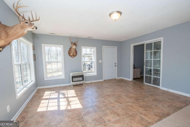 interior space featuring heating unit, baseboards, and tile patterned floors