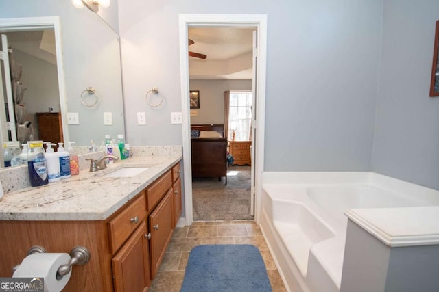 full bath featuring a garden tub, a ceiling fan, vanity, ensuite bath, and tile patterned floors