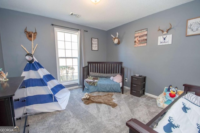 carpeted bedroom with visible vents and baseboards