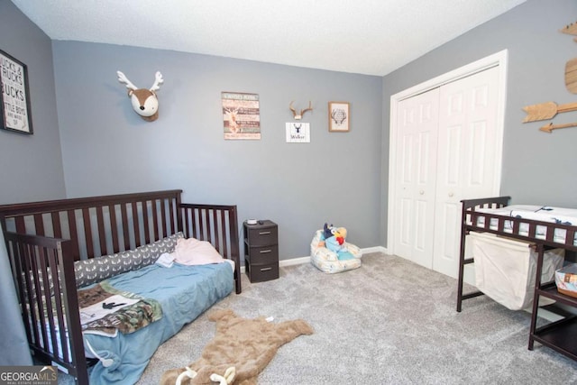 carpeted bedroom with baseboards and a closet