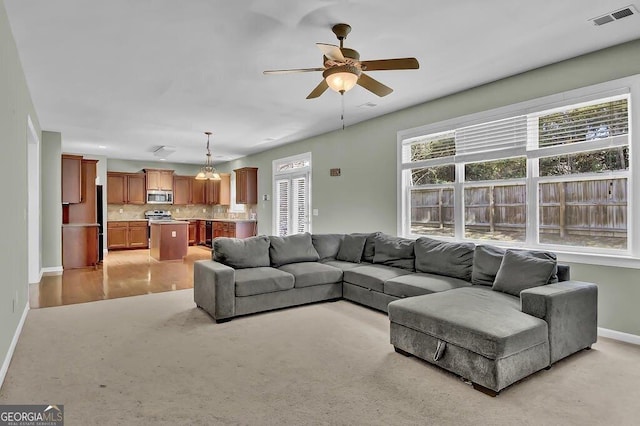 living room with visible vents, ceiling fan, and baseboards