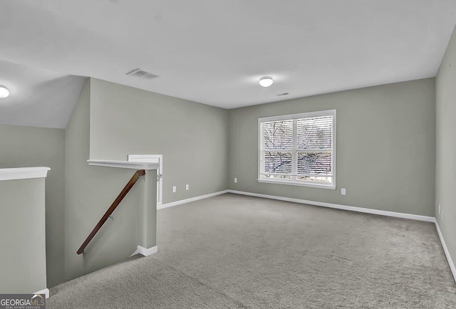 carpeted spare room with visible vents and baseboards