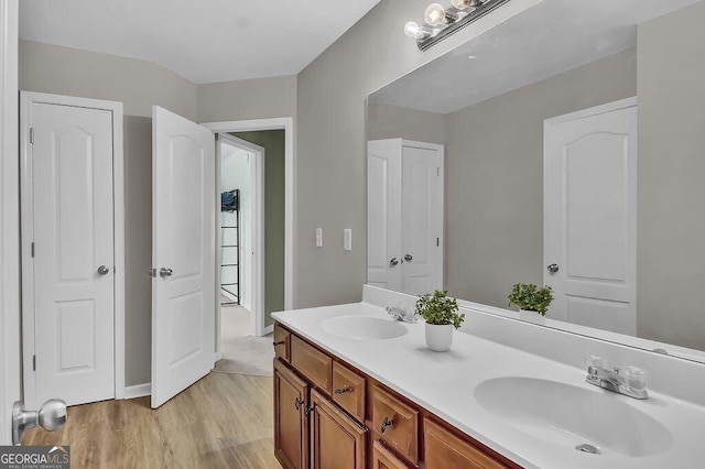 bathroom featuring double vanity, a sink, and wood finished floors