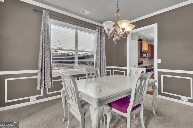 dining room featuring visible vents, ornamental molding, a notable chandelier, and light colored carpet