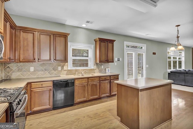 kitchen featuring stainless steel appliances, a sink, visible vents, light wood-type flooring, and a center island