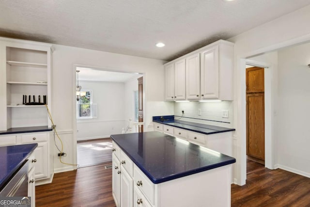 kitchen featuring dark wood-type flooring, dark countertops, white cabinets, and open shelves