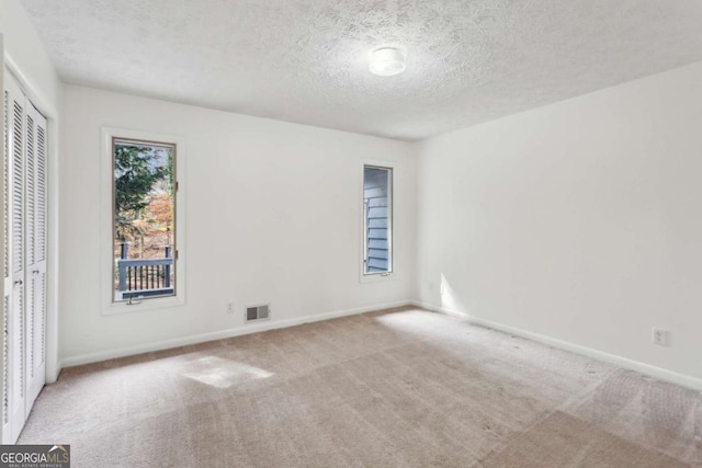 unfurnished bedroom featuring carpet floors, a closet, visible vents, and baseboards