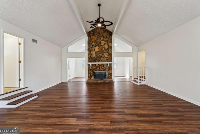 unfurnished living room featuring a textured ceiling, high vaulted ceiling, a fireplace, wood finished floors, and visible vents