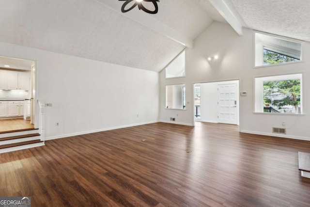 unfurnished living room featuring dark wood-style floors, visible vents, beamed ceiling, and baseboards