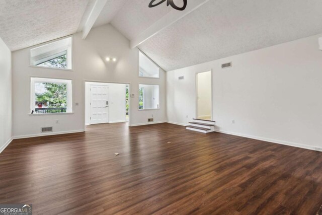 unfurnished living room featuring a healthy amount of sunlight, visible vents, and dark wood-style flooring