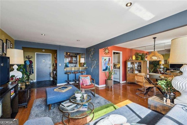 living area with baseboards and wood finished floors