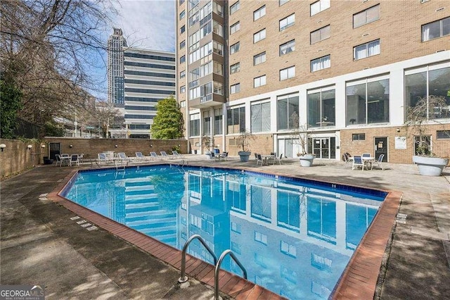 community pool with fence and a patio