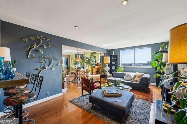 living area with baseboards and wood finished floors