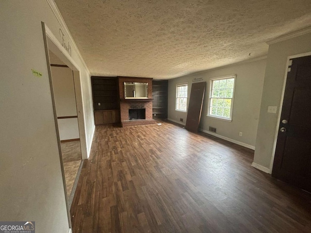 unfurnished living room featuring a textured ceiling, ornamental molding, a fireplace, and dark wood finished floors