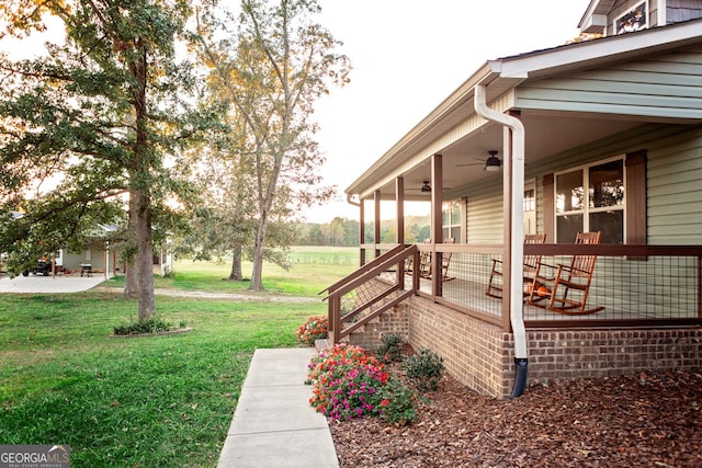 view of yard featuring covered porch and ceiling fan