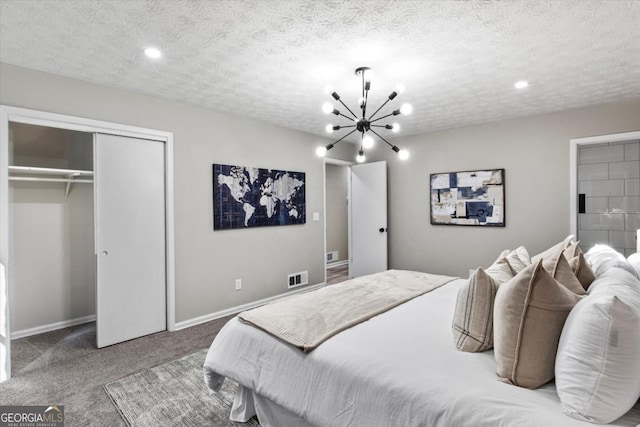 bedroom featuring a textured ceiling, carpet flooring, visible vents, a closet, and an inviting chandelier