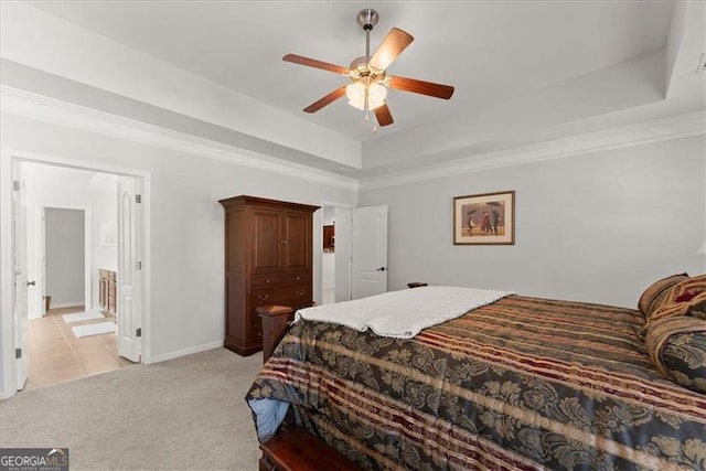 bedroom featuring ceiling fan, light carpet, baseboards, a raised ceiling, and crown molding